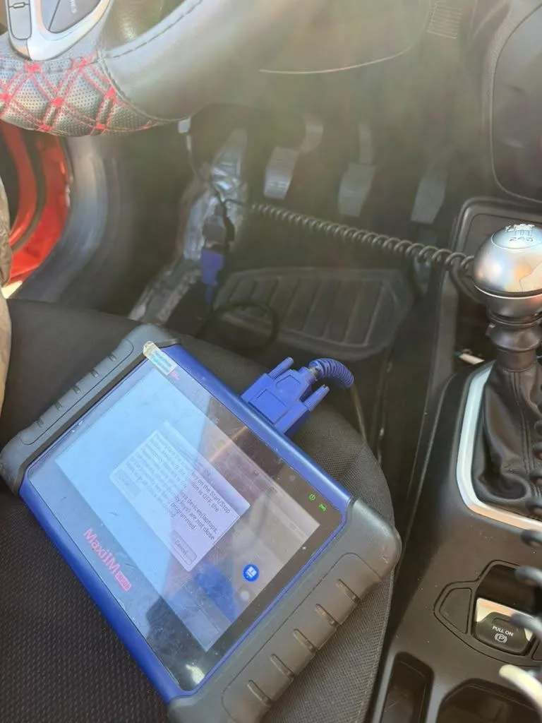 Key programming tablet set up inside a car and connected to the vehicle.